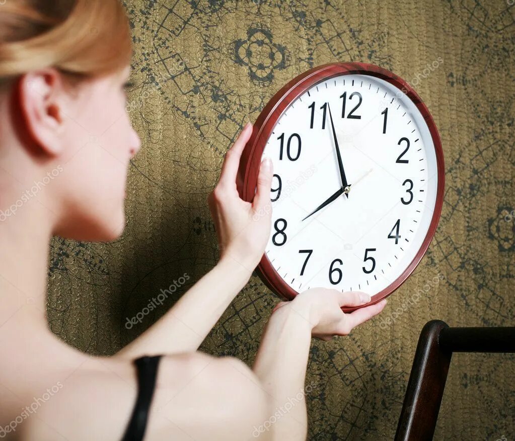 Женщина с настенными часами. Женщина вешает часы на стену. Фотография девушки с настенными часами. Чел держит настенные часы.