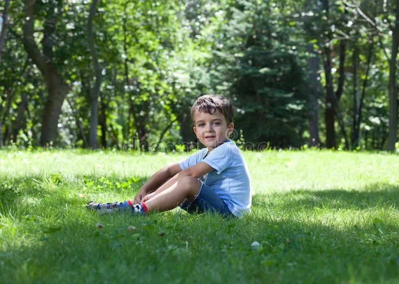 Мальчик сидит на траве. Мальчик сидит в парке на траве. Подросток сидит на траве. Мальчик сидит на земле.