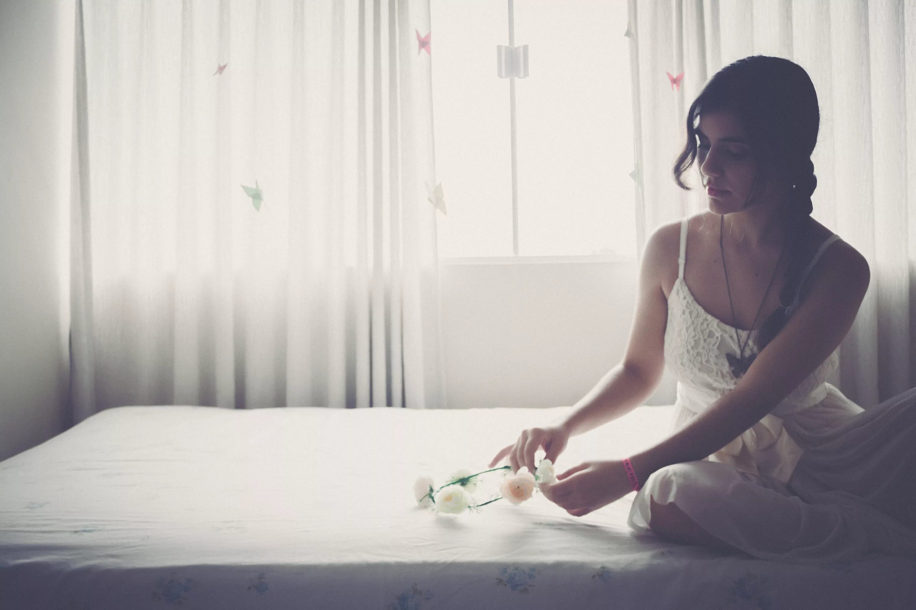 Белая комната для девушки. Спокойная девушка. Девушка в платье на кровати. Портрет сидящей девушки. Спокойная девушка какая