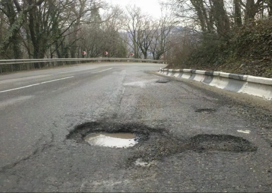 Выбоина на дороге. Дорога с ямами и выбоинами. Глубокие выбоины на дороге. Наличие выбоин на дороге.