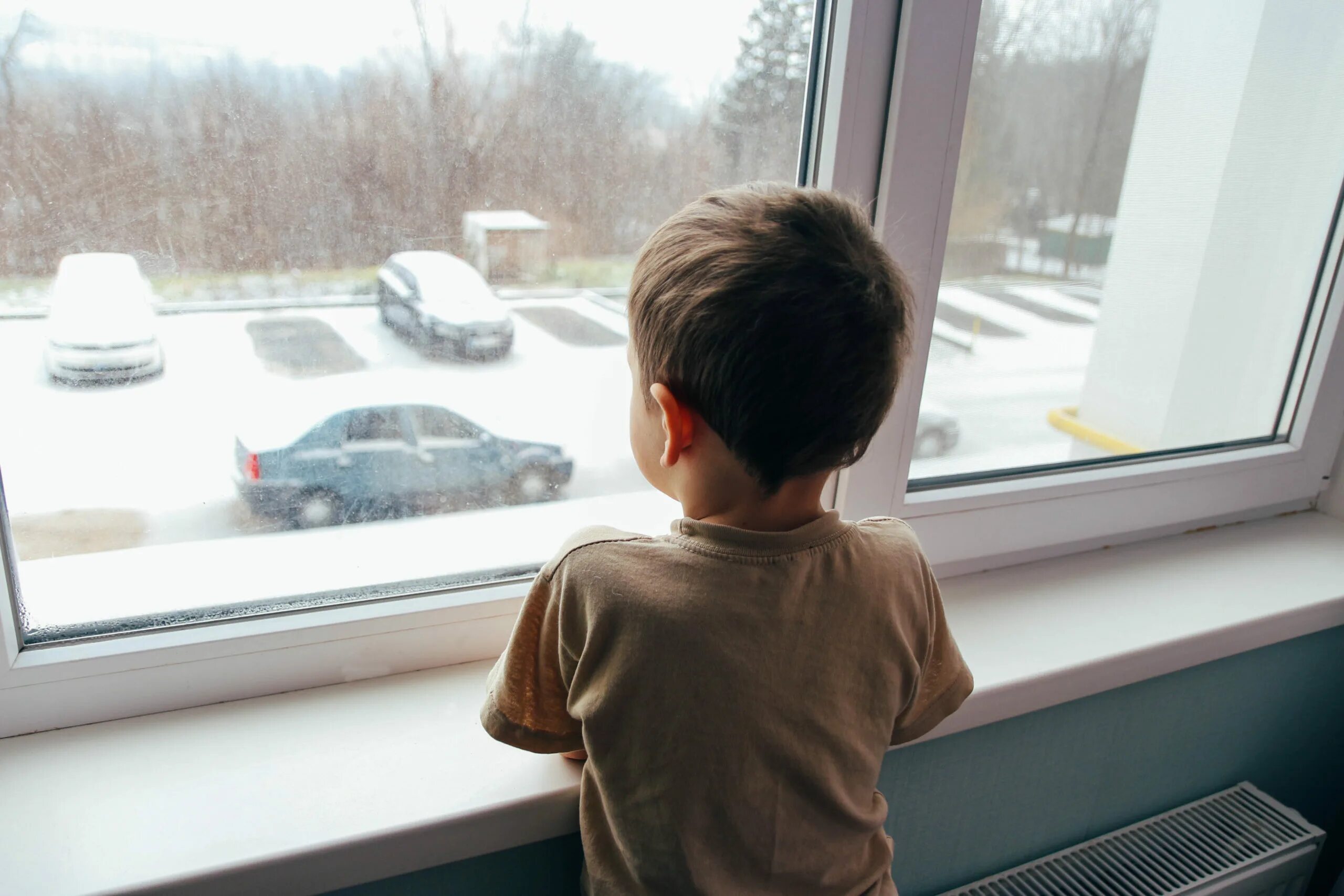 Ребенок смотрит в окно. Мальчик смотрит в окно. Мальчик из детдома. Мальчик смотрит.
