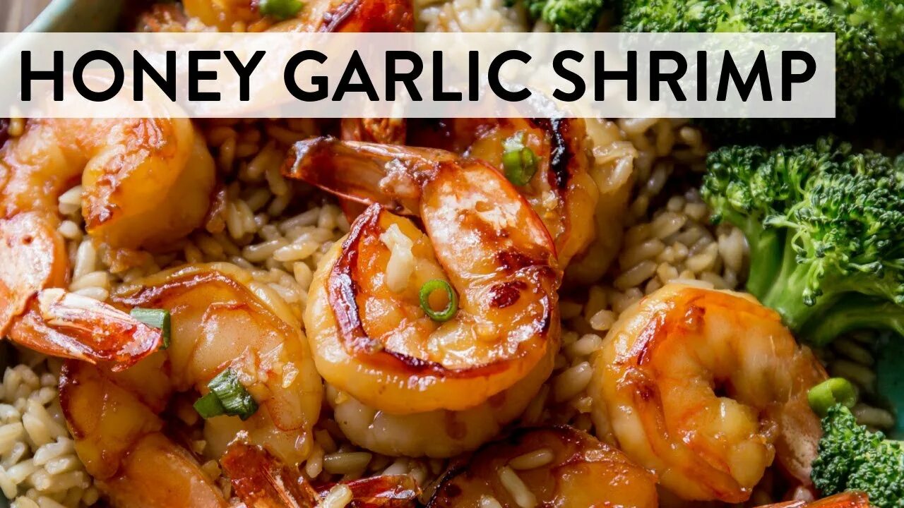 Glass baking dish filled with bake shrimp and garlic butter sauce, garnished wit