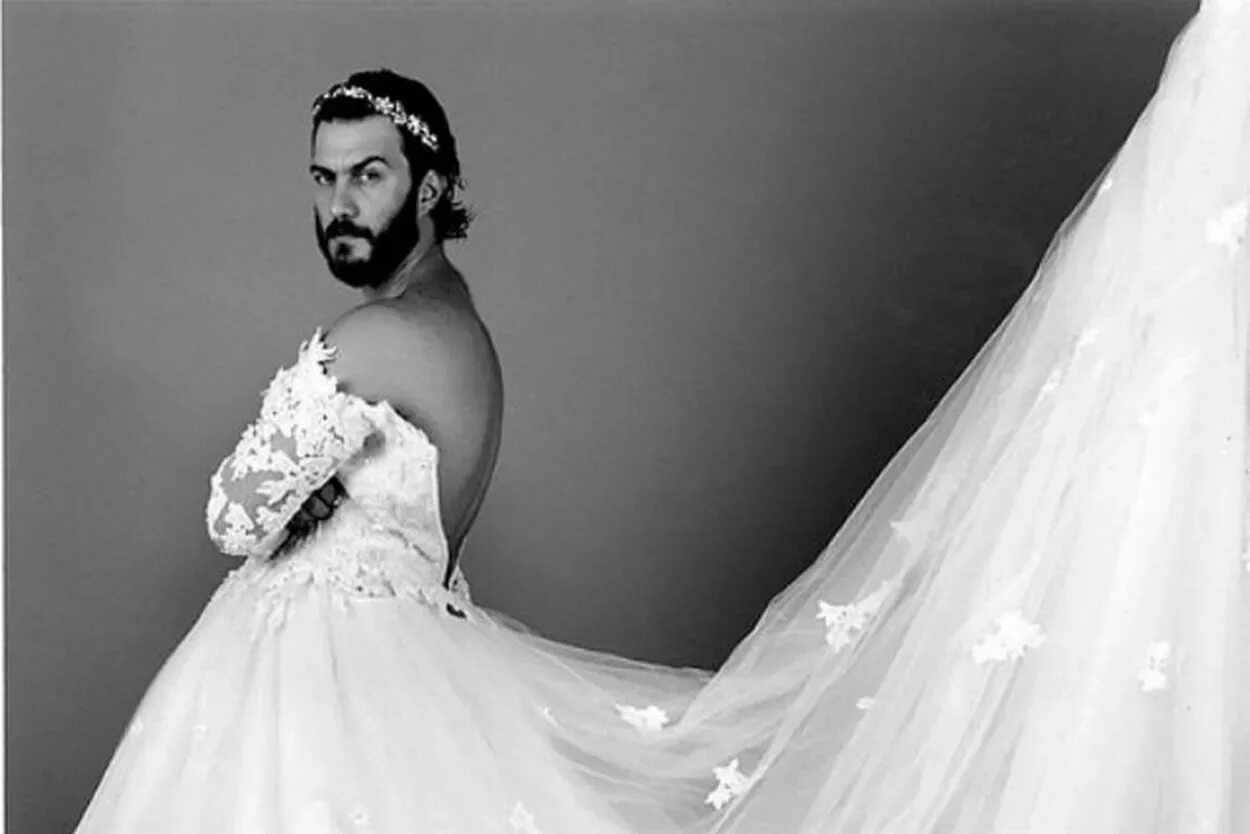Жених и невеста сказочные. Свадебные платья с фатой. Свадебная фотосессия на море. Мужское свадебное платье. Невеста на кровати.