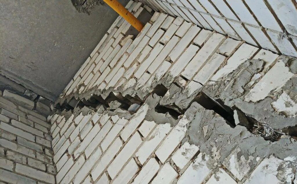 Без трещин. Трещина в многоэтажном доме. Разрушение строительных конструкций. Дефекты кирпичной кладки. Трещина в несущей стене.