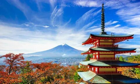 Autumn color surrounds a pagoda in Fujiyoshida, Japan as Mount Fuji looms i...