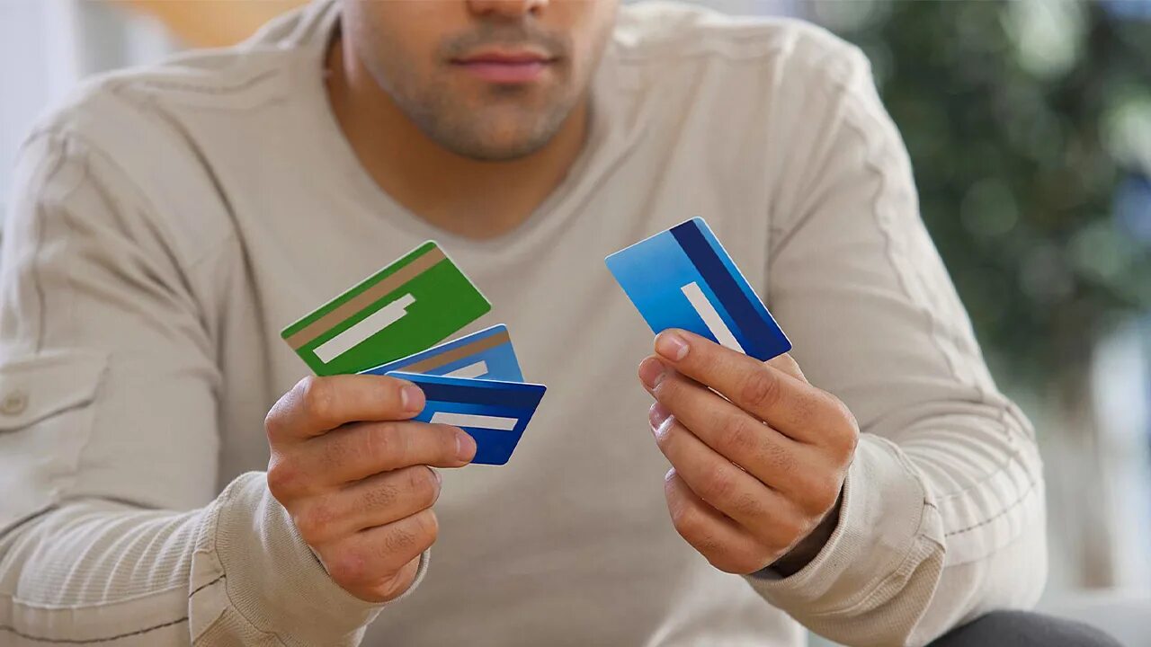 Кредиты в жизни человека. Мужчина с кредиткой. Карточка человека. Мужчина с картой банка. Много банковских карт в руке.