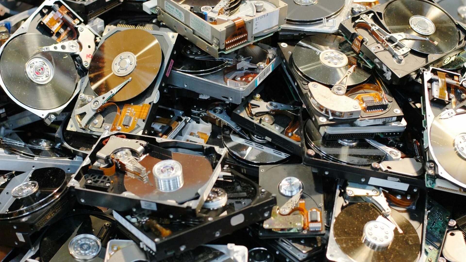 Компьютерный диск. Много жестких дисков. Жесткие диски куча. Свалка жестких дисков.