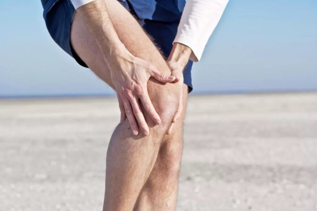 Изменения в коленных суставах. Боль в суставах. Боль в колене. Человек держится за колено.