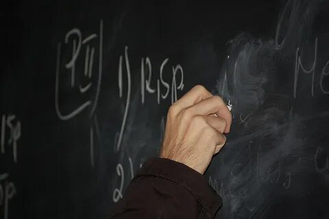 The teacher writes on the blackboard