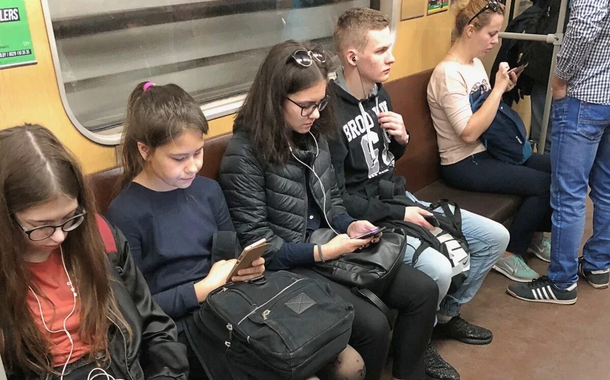Где сидят молодые. Люди с гаджетами в транспорте. Современное метро люди. Школьники в метро. Люди с телефонами в метро.