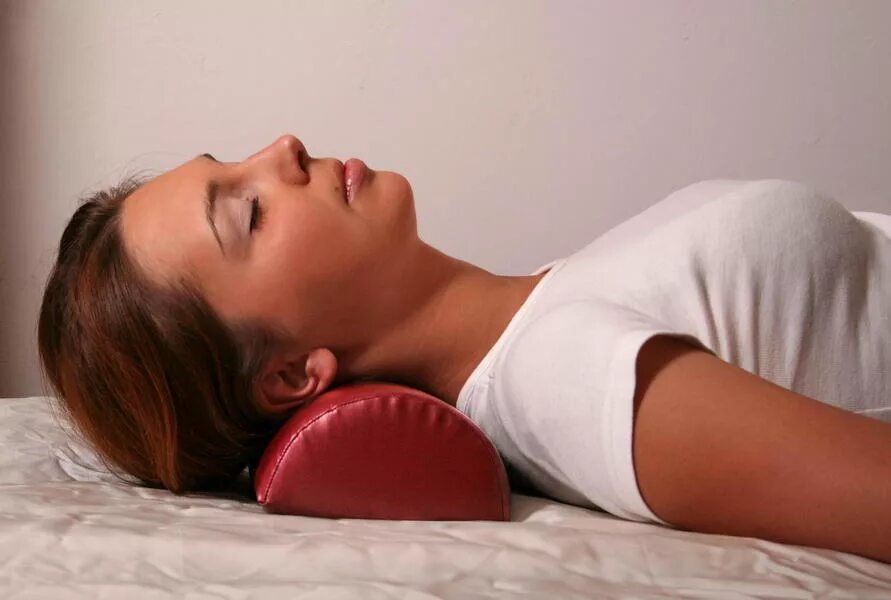 Подушка валик ортопедическая. Подушка валик для сна при остеохондрозе. Подушка валик как правильно спать. Лежит на спине. Подушка для сна на спине.