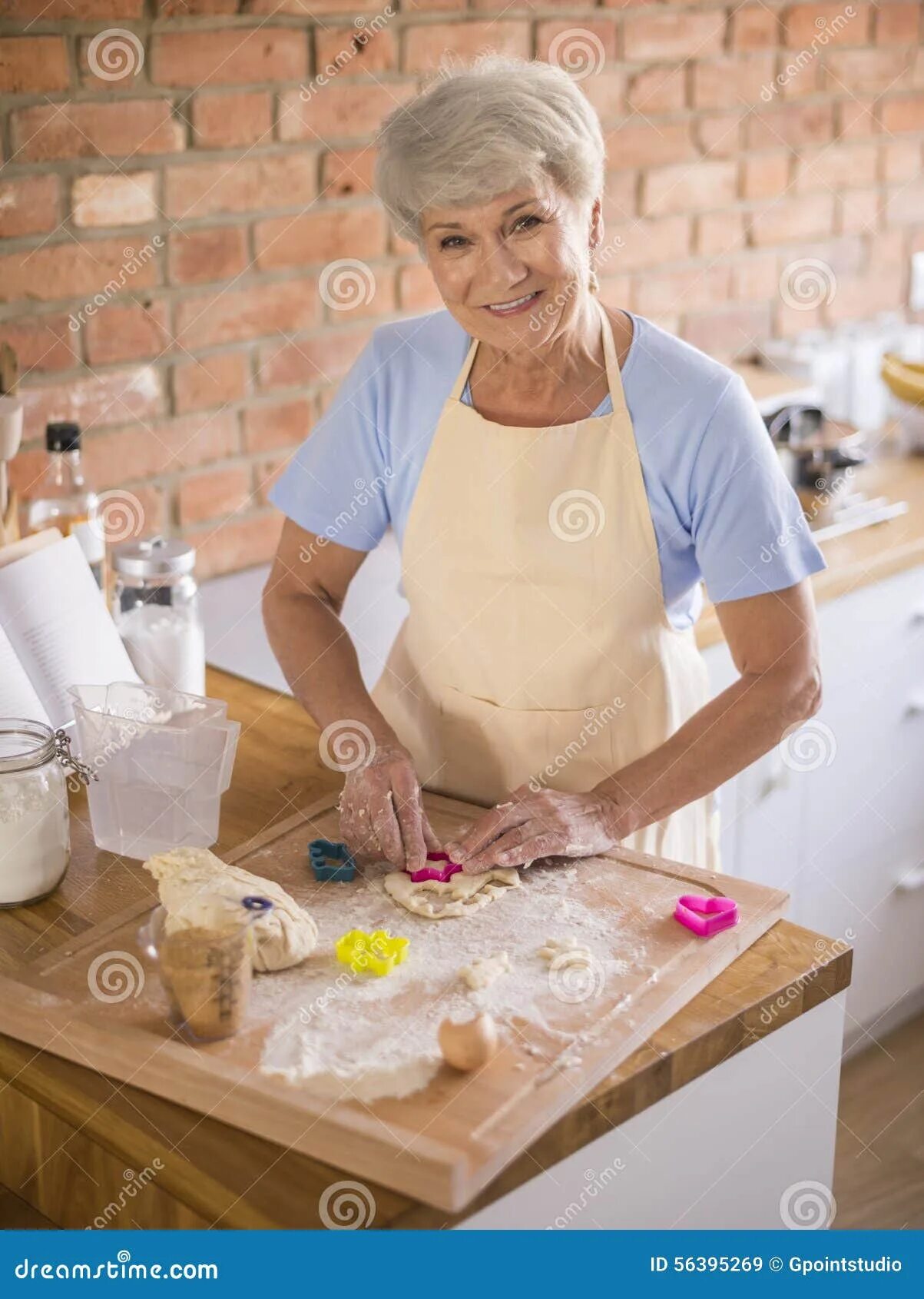 Grandmas cooking. Пожилая женщина на кухне. Grandmas cooking. Пожилая женщина на кухне. Бабушка ест на белом фоне.