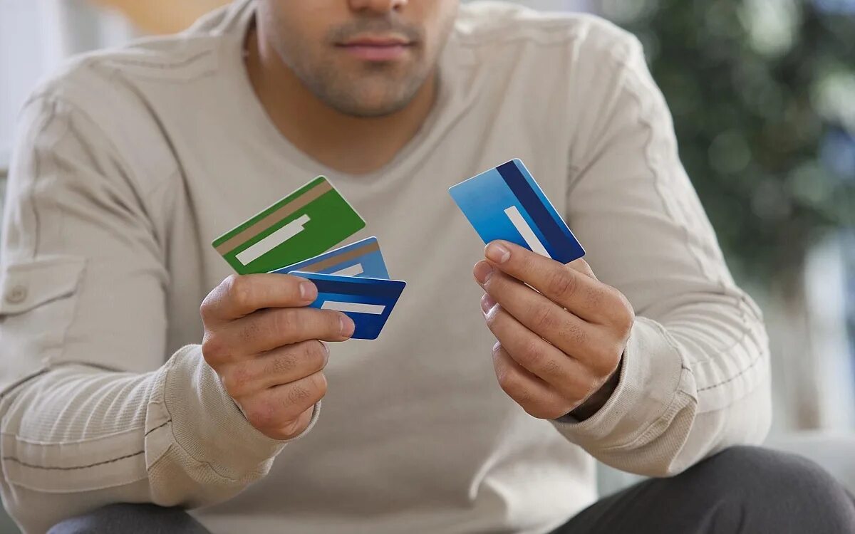 Bank debt. Мужчина с кредиткой. Карточка человека. Мужчина с картой банка. Много банковских карт в руке.