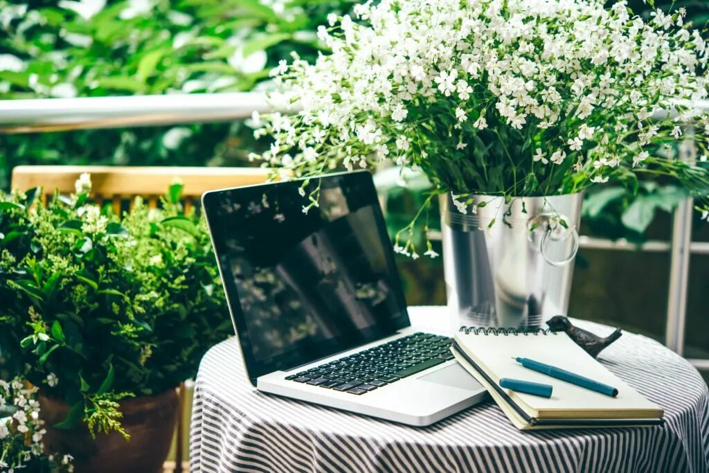 Вокруг стола книга. Ноутбук и цветы. Ноут с цветами на столе. Ноутбук и ромашки. Ноутбук стол цветы красиво.