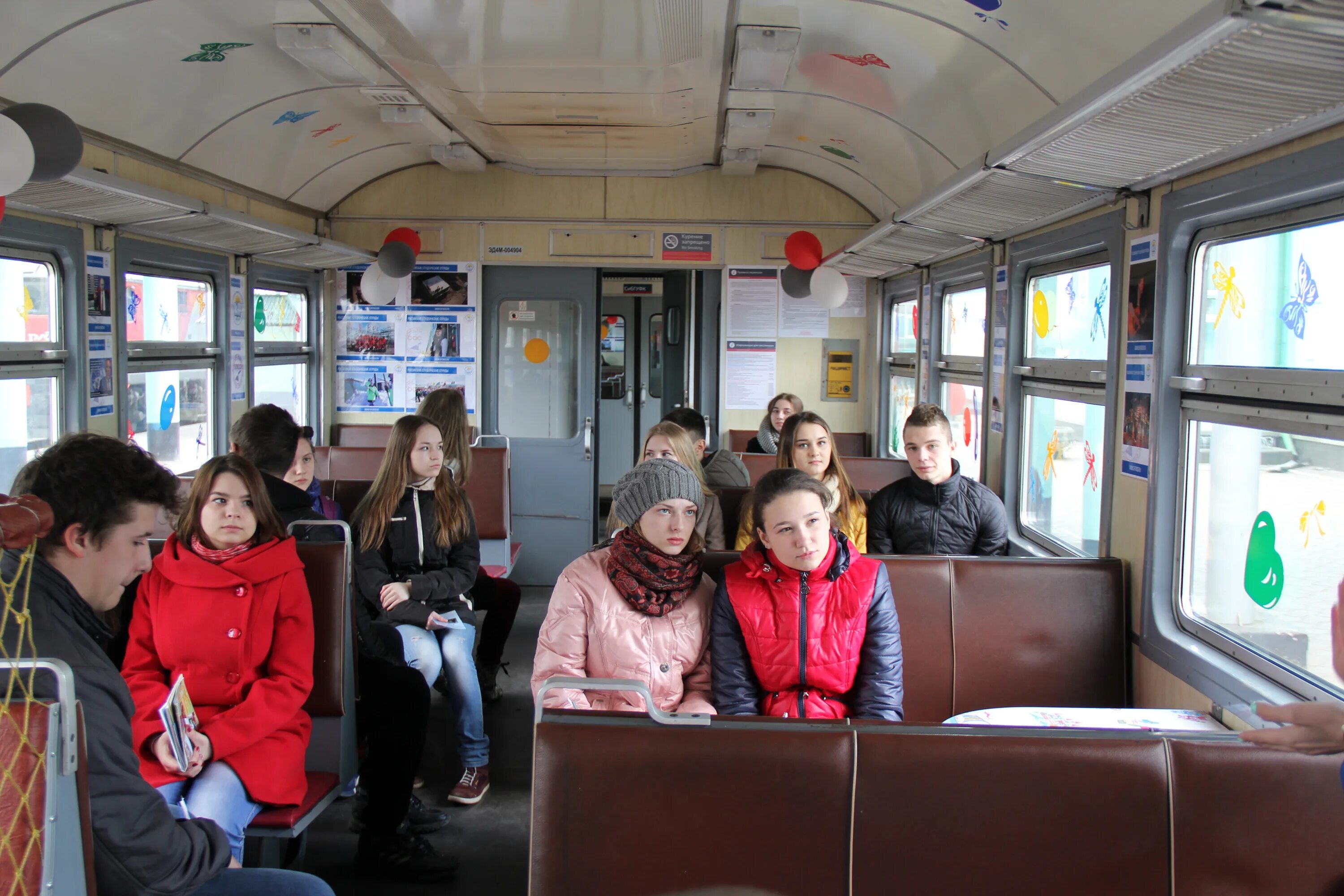 люди в электричке. студенты в пригородном поезде. пассажиры в электричке. проездом на вокзале. подростки в общественном транспорте.