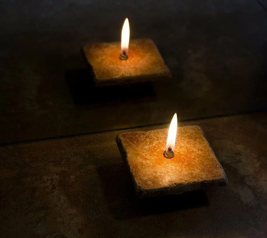 Тепло свечи. Отражение пламени свечи на предметах. Дерево с коричневыми свечками. Свеча светящаяся в темноте.