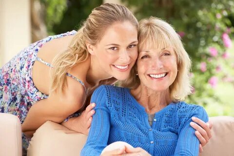 Senior Woman With Adult Daughter Relaxing On Sofa At Home.