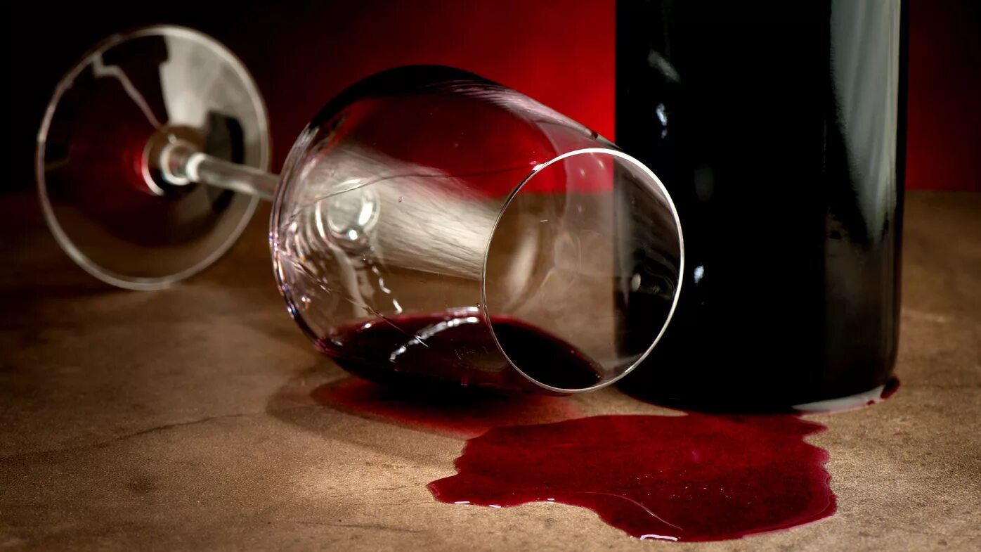 Опрокинутый бокал с вином. Пол бокала вина