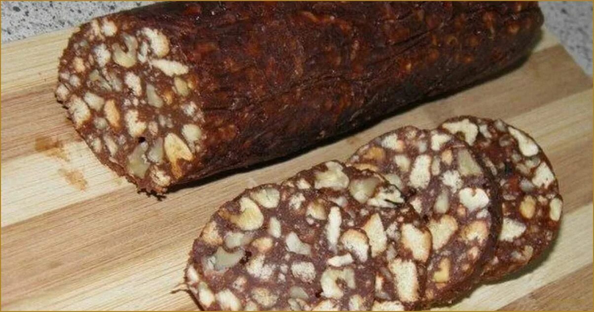 Колбаска из печенья со сгущенкой и орехами. Сладкая колбаска. шоколадная колбаска из печенья. сладкая колбаска из печенья и какао. сладкая колбаса с печеньем.