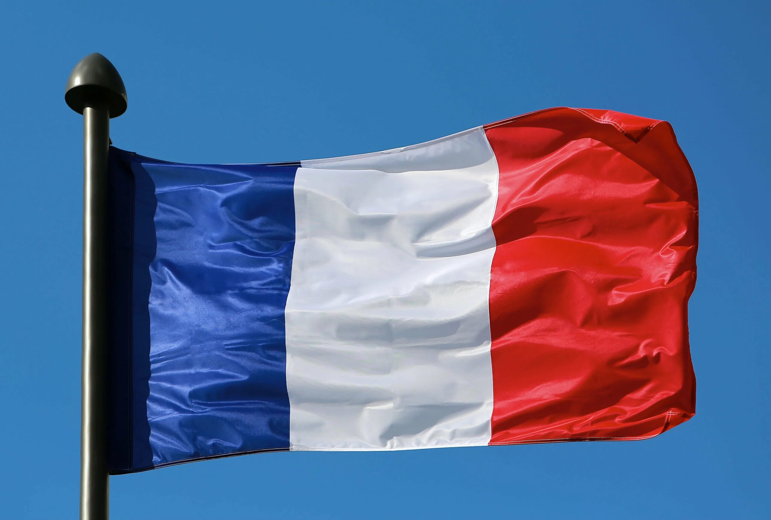 Флаг Франции. Французский флаг на ветру. Флаг Франции на флагштоке. Флаг Франции на фоне неба.