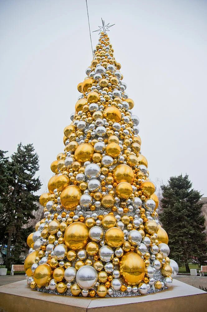 Золотая елка. Наряженная елка на улице. Золотые шарики на елку. Большие елки.