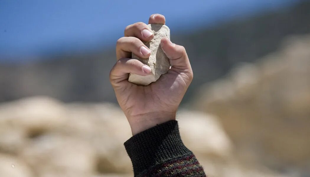 Рука держит камень. Каменный человек. Парень на камне. Камень в руке. Кидает камень.