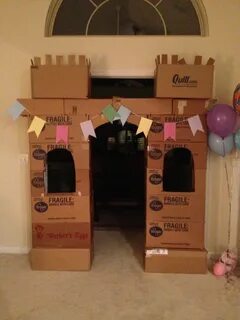 there is a cardboard castle with balloons on the floor and a sign that says...