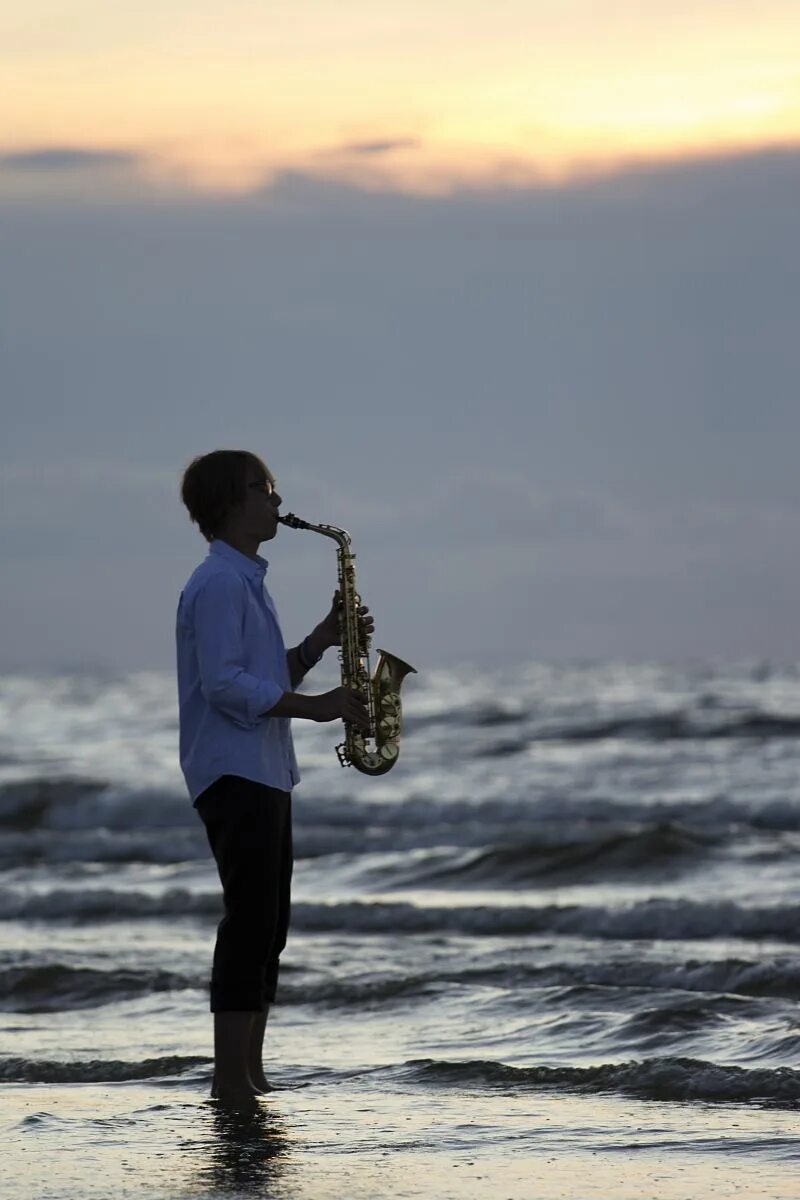 Нежная музыка саксофон. Саксофонист. Саксофонист на берегу моря. Человек на берегу моря. Человек возле моря.