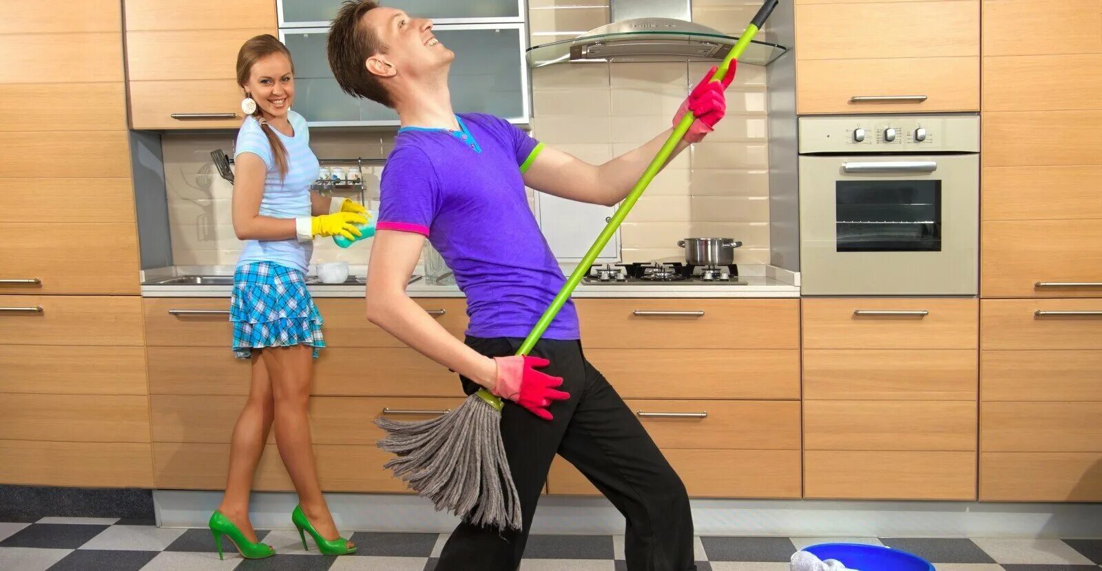 Девушка с парнем убираются. Мытье пола на кухне. Уборка кухни. Мужчина и женщина убираются в доме. День домработницы