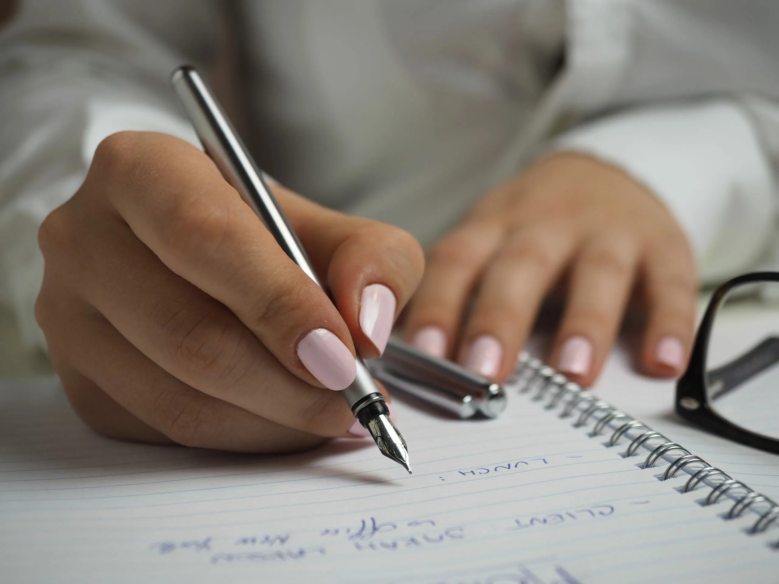 Человек пишет на листе бумаги. Рука с ручкой. Рука пишет ручкой. Письменная работа. Женская рука с ручкой.