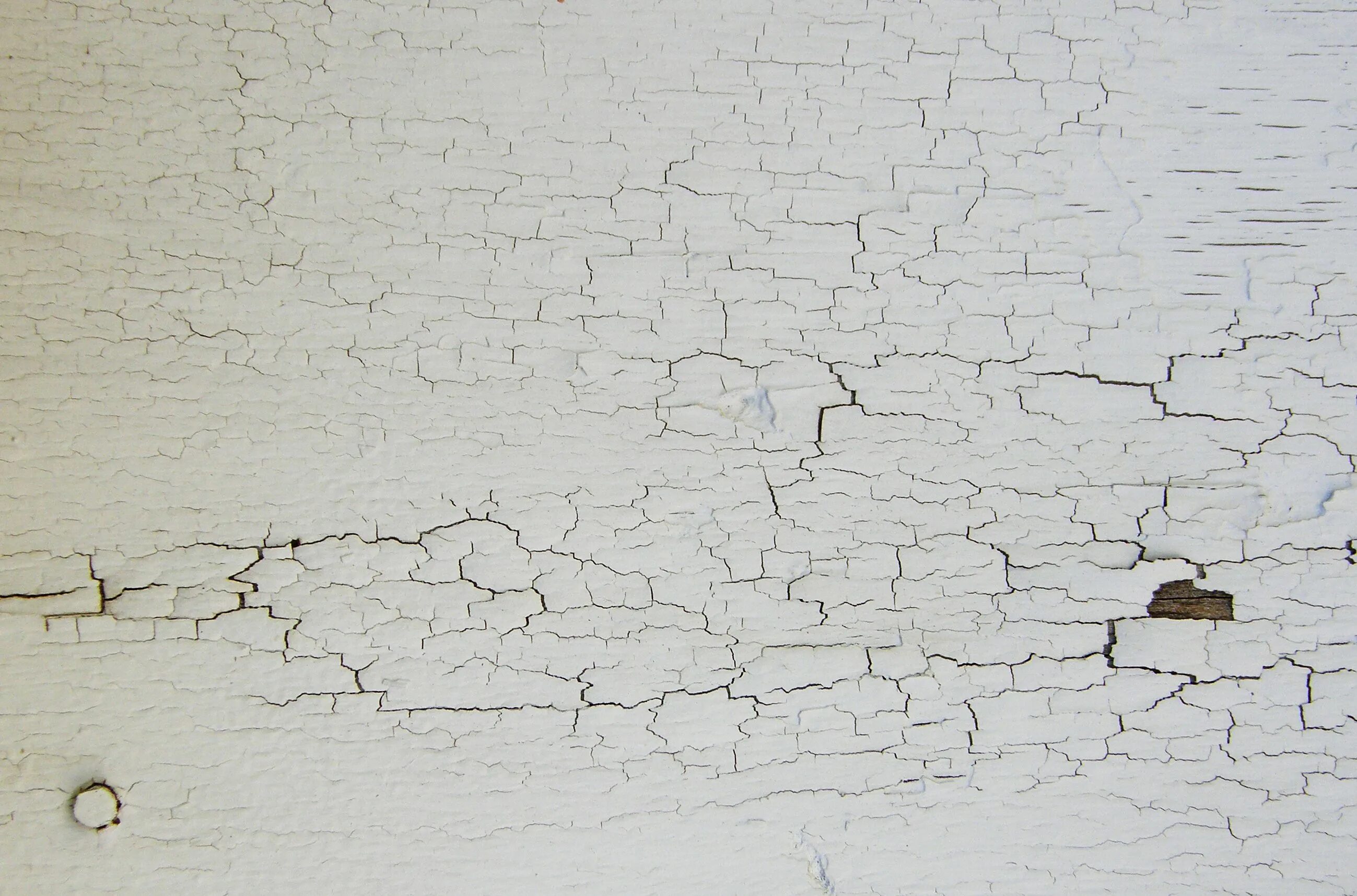 Облупившаяся краска на стене. Трещина в стене. Текстура стены. Потрескавшаяся краска на стене.