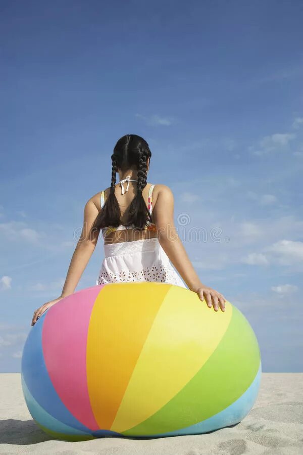 Девушка на надувном мяче. Девушка сидит на надувном мяче. Девушка с пляжным мячиком. Девушка на пляжном мяче.