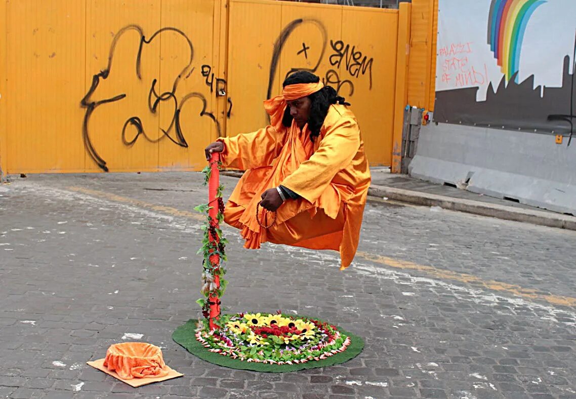 падающий человек. живые скульптуры на улице. секрет левитации уличных артистов. человек висит в воздухе. человек сидит в воздухе.