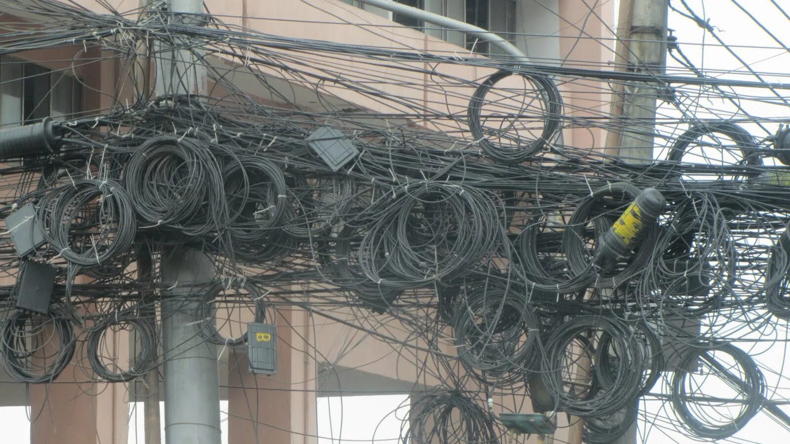 Запутались мы в городах. Столб для кабеля. Много проводов на столбе. Провода в Азии. Электрика в Тайланде.