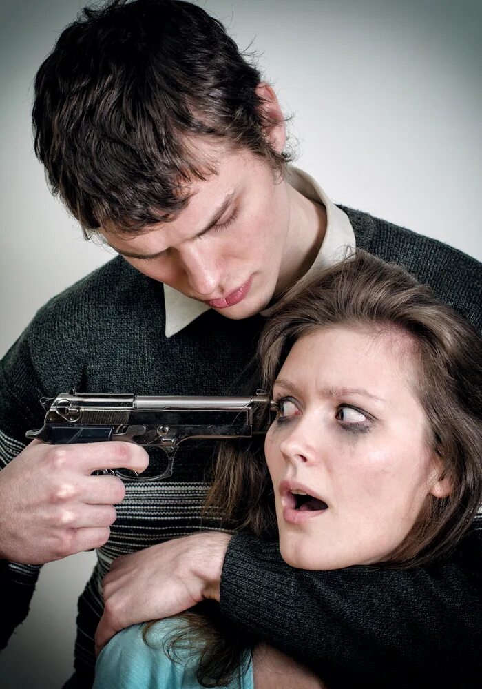 Девушка угрожает парню. Человек угрожает пистолетом. Мужчина и женщина с пистолетами.
