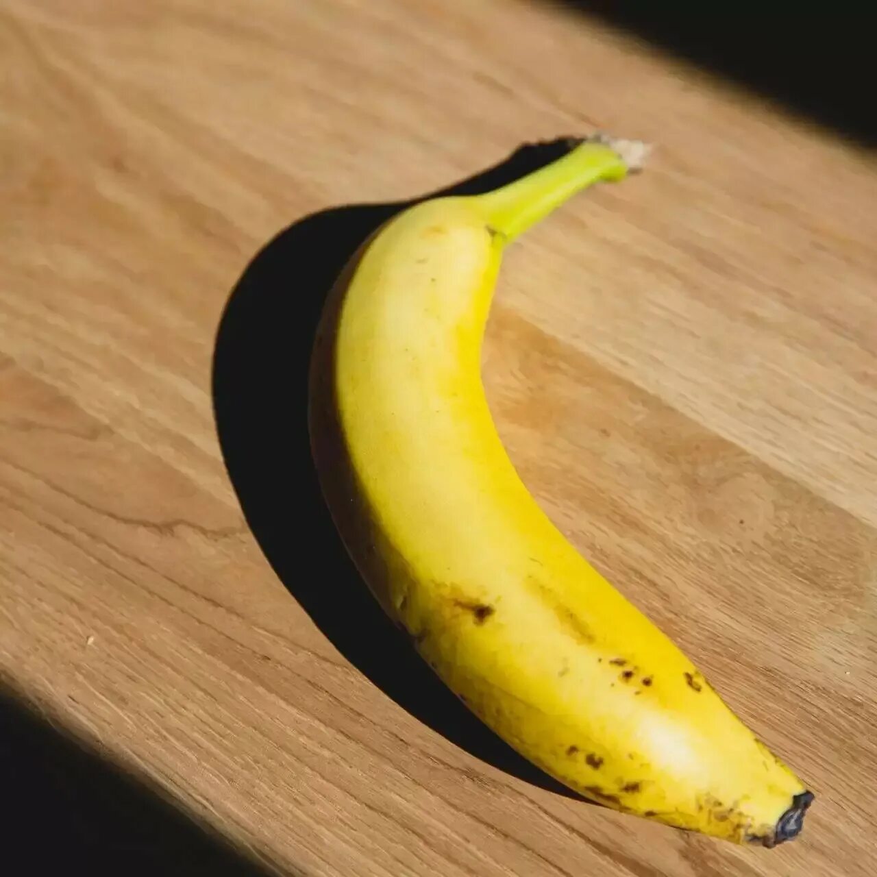 Сколько лежат бананы. Банан. Банан на столе. Неспелый банан. Банан лежит.