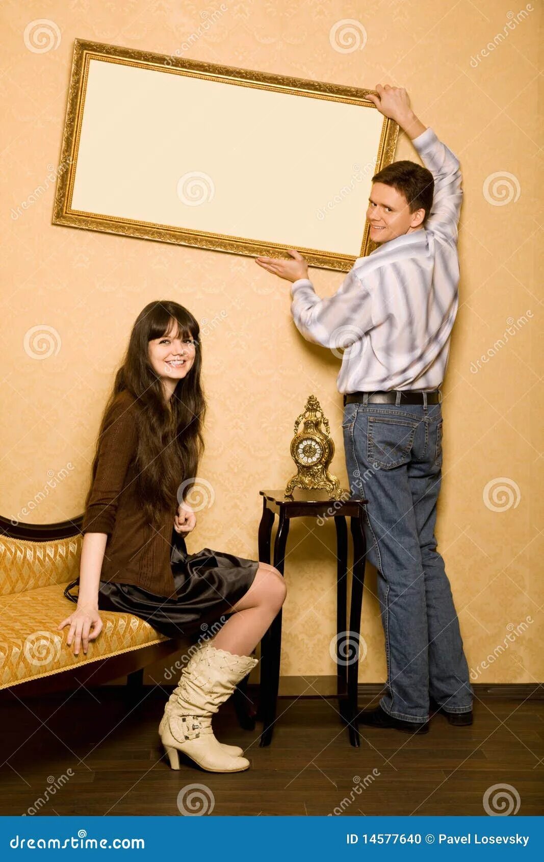 Повесить девушек. Поправляет картину. Мужчина вешает картину. Девушка вешает картину. Девушка вешает фото на стену.