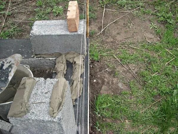 Первый ряд керамзитобетонных блоков. Армирование кладки шлакоблока. Приспособление для укладки керамзитобетонных блоков на раствор. Приспособление для кладки бессер блоков. Кладка шлакоблока своими.