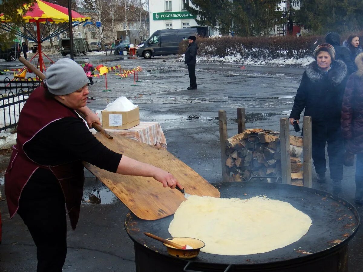 Масленица пекут блины. Огромный блин на Масленицу. Гигантская сковорода. Самый большой блин на Масленицу. Пекут блины стоит веселый