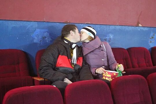 Парень с девушкой в кинотеатре. Влюблённые в киеотеатре. Места для поцелуев в кинотеатре. Люди сидят в кинотеатре. Фотосесияв кинотеатре.