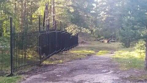 Окружен забором