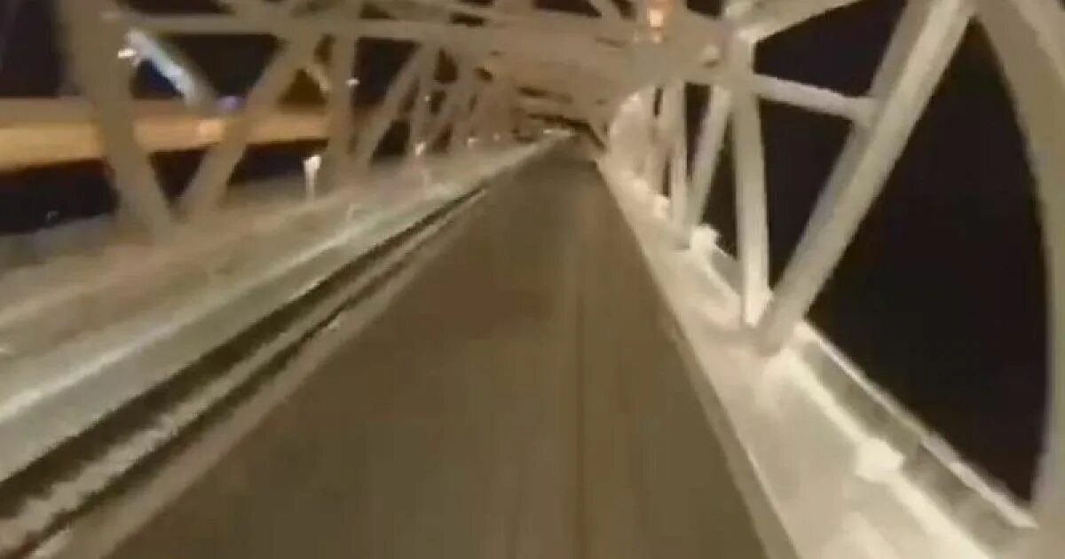 Поезда едут через крымский мост. Мужчина залез на Крымский мост.
