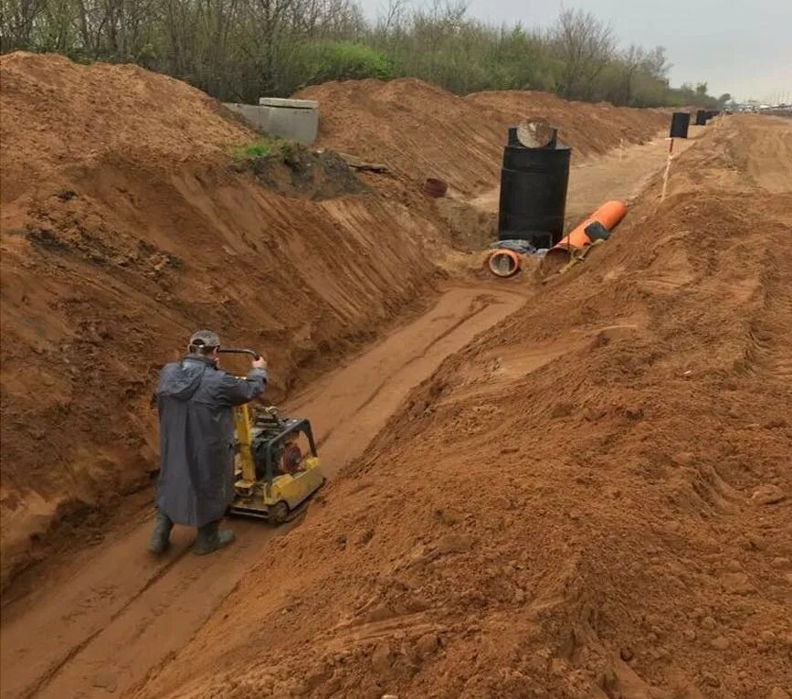 Земляная засыпка. Уплотнение грунта засыпка котлована. Засыпка котлована песком. Трамбовка котлована. Трамбовка траншеи.