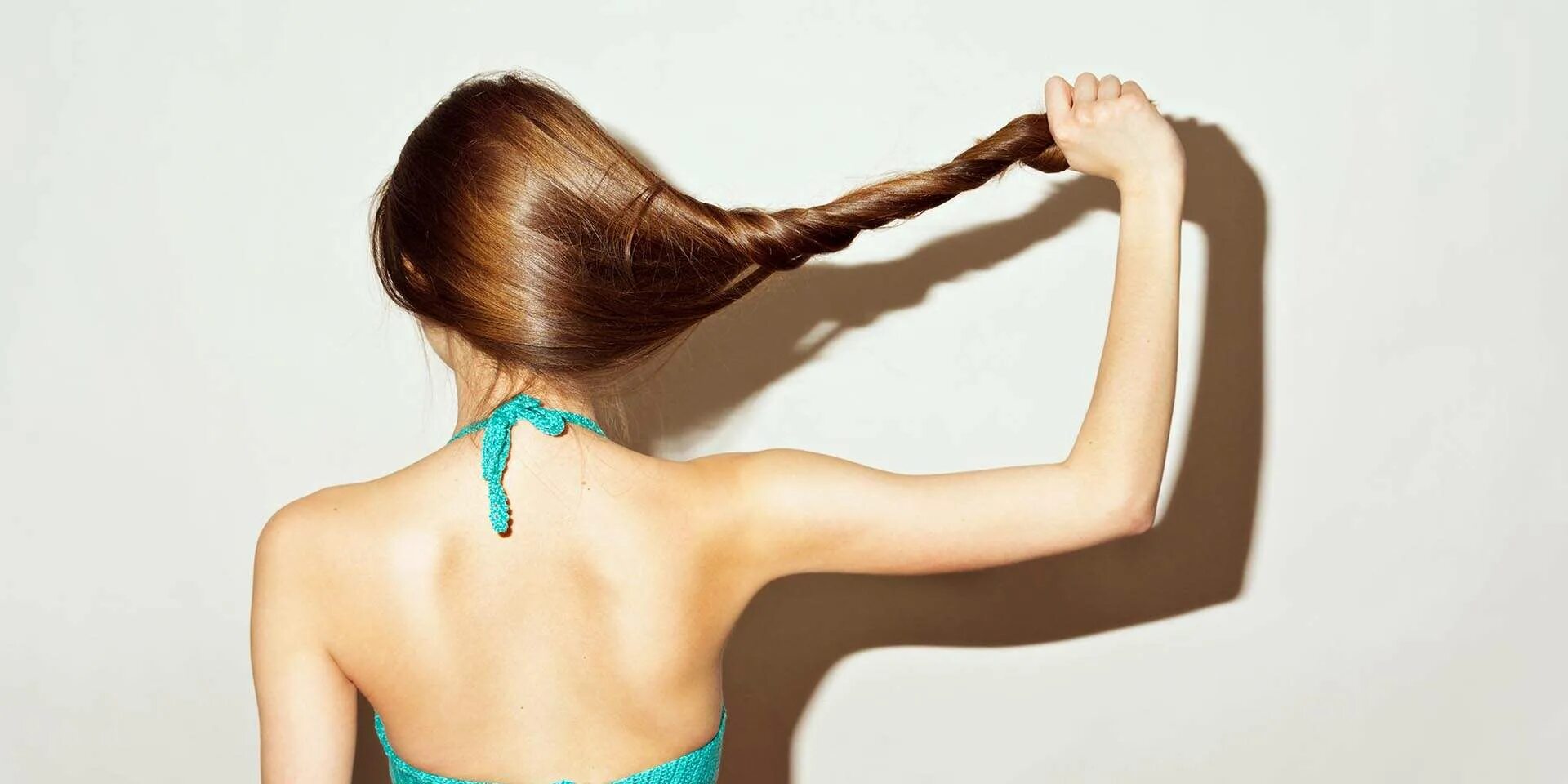 Под каждым хвостом. Девушка держит волосы. Здоровые волосы. Волосы в хвостик у девушек. Волосы тянутся.