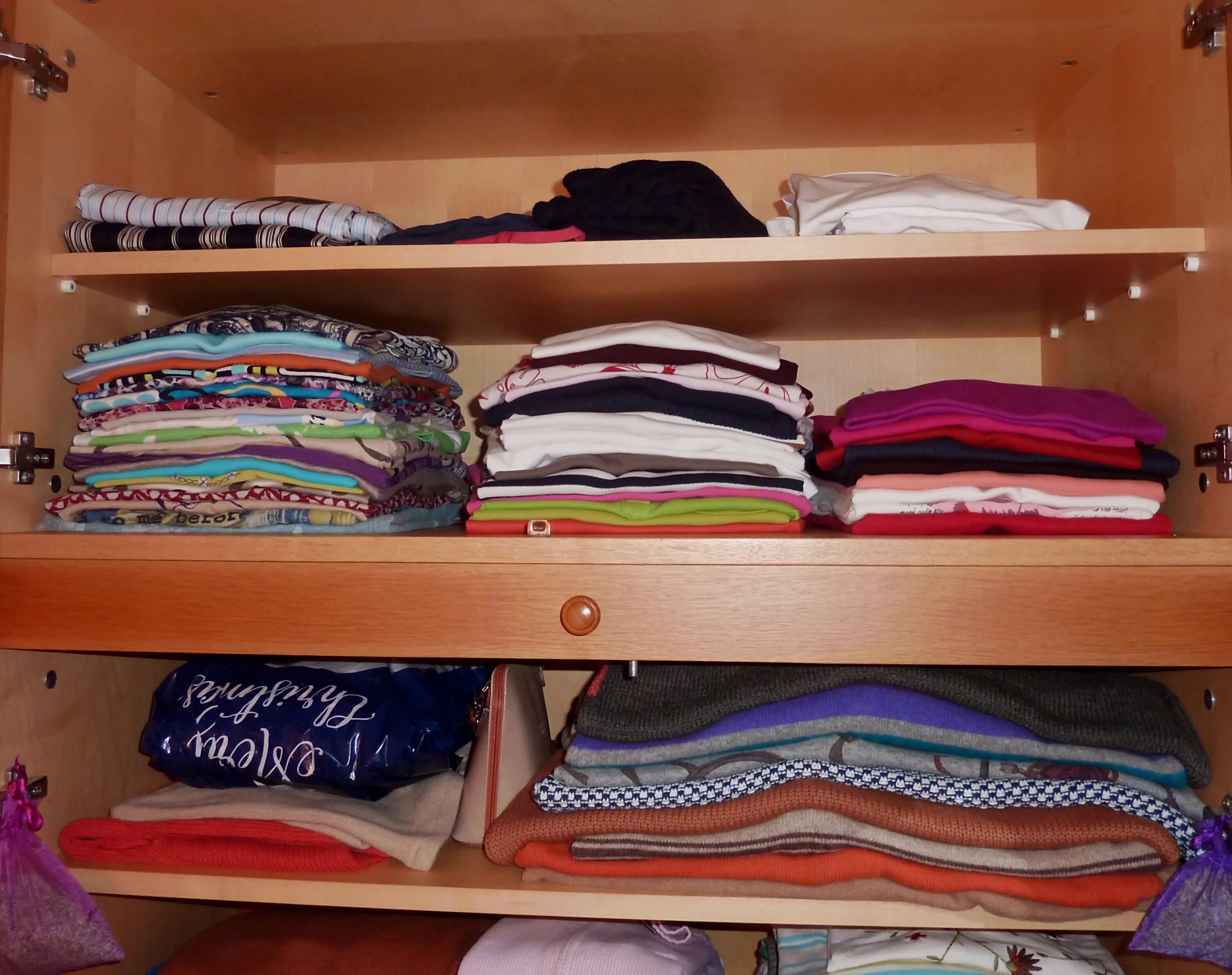 В квартире появляются вещи. Порядок в шкафу. Шкаф с вещами. Шкаф для одежды. Порядок на полке в шкафу с одеждой.