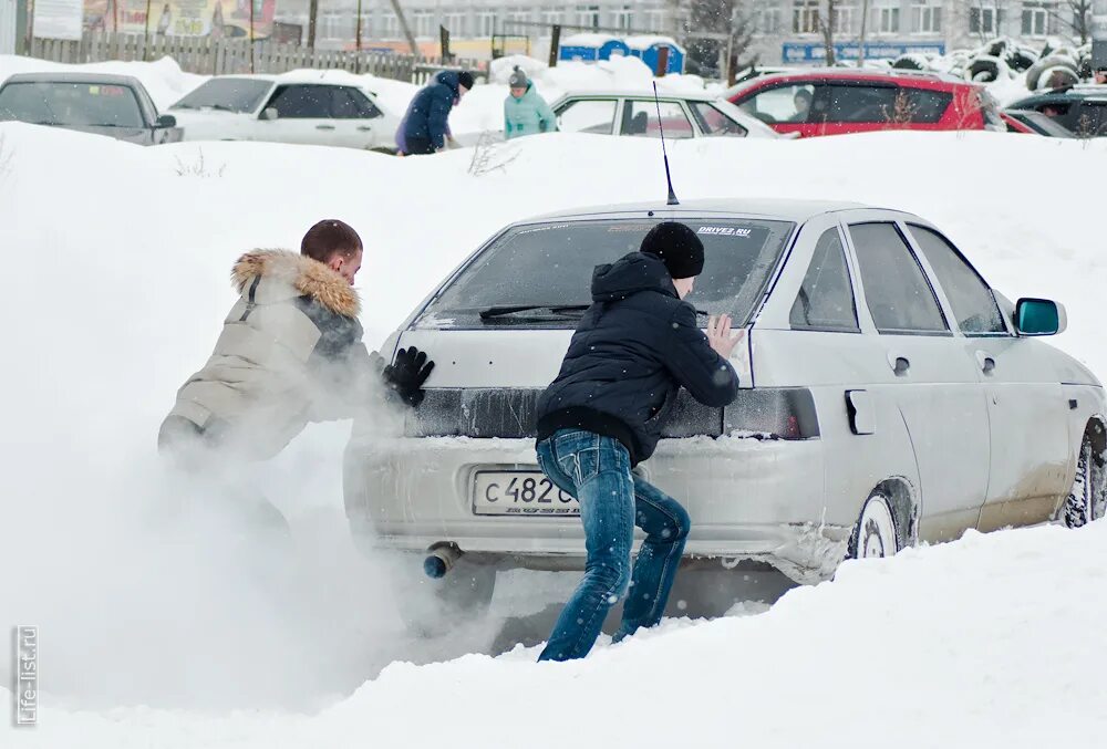 Застревают в сугробах. Толкают автомобиль. Машина в снегу. Толкают машину зимой. Машина в сугробе.