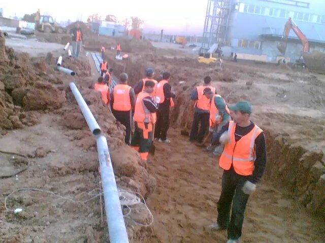 производит земляные работы. прокладка кабельной линии 6-110 кв. прокладка кабелей 110кв в траншее. карьер земляные работы. земляные работы вблизи кабельной трассы.