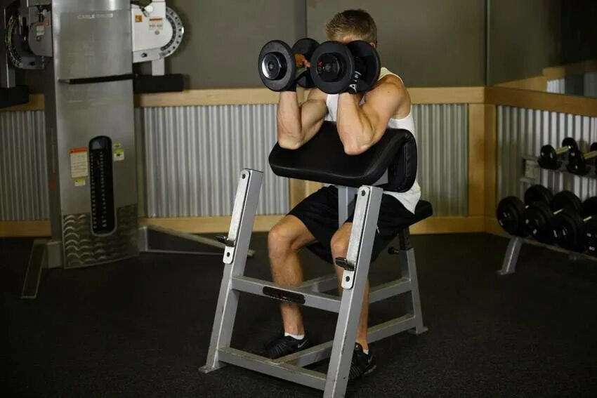 Подъем ez штанги на бицепс на скамье скотта. Подъем ez штанги на бицепс на скамье скотта. Подъем гантелей на бицепс в скамье скотта. Скамья ларри скотта. На скамье скотта ez-штанги.