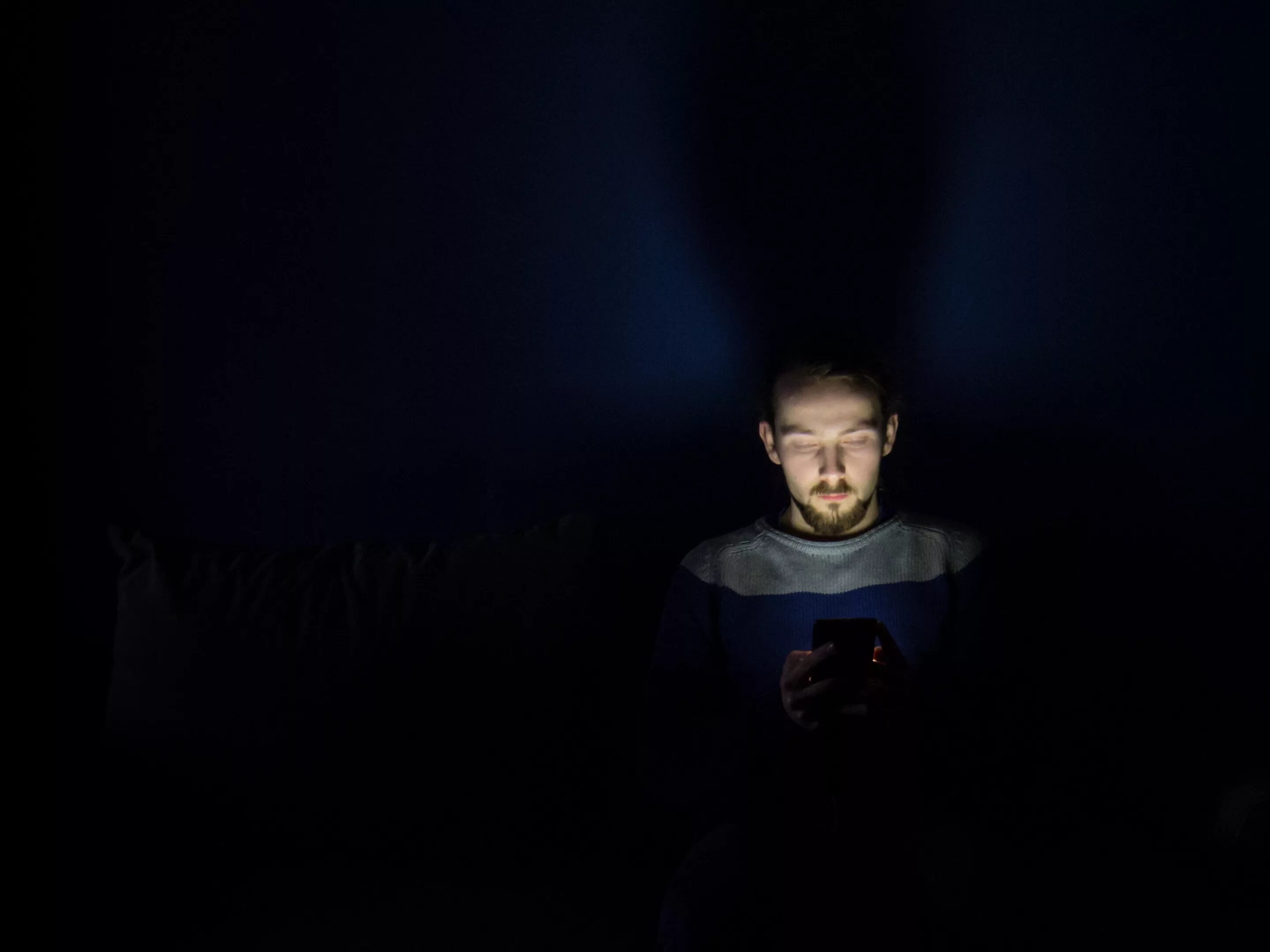 Теряюсь в темноте. Человек с фонариком в темноте. лицо в темноте. сидит в темноте. парень с телефоном в темноте.