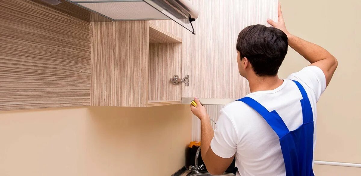 Мужчина кухонный шкаф. Рабочий собирает кухню. Сборщик мебели. Демонтаж мебели. Сборка мебели сколько процентов от стоимости мебели.